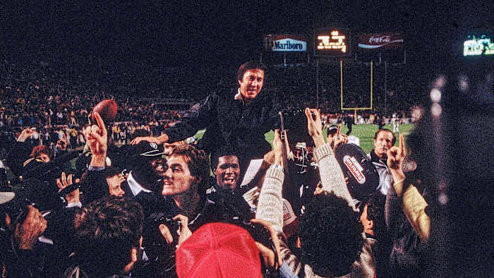 Tom Flores is carried off the field after Super Bowl XVIII